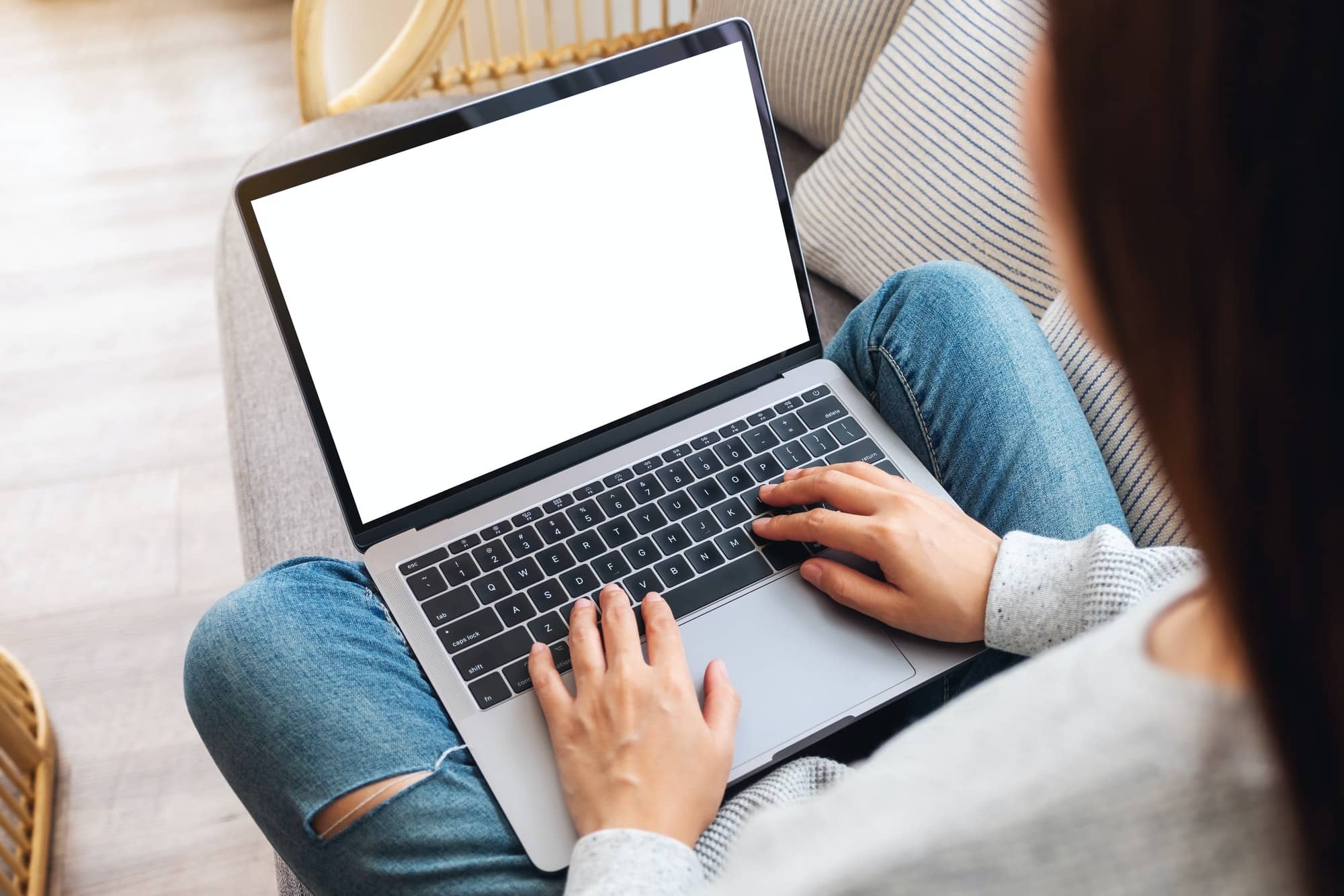 a woman working and typing on laptop computer with blank screen
