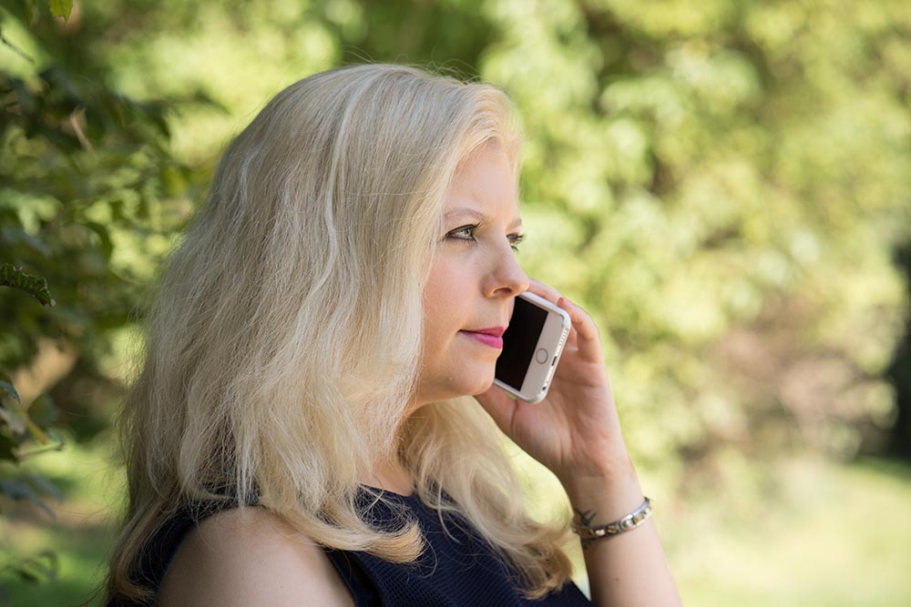 A woman standing outside while talking on the phone