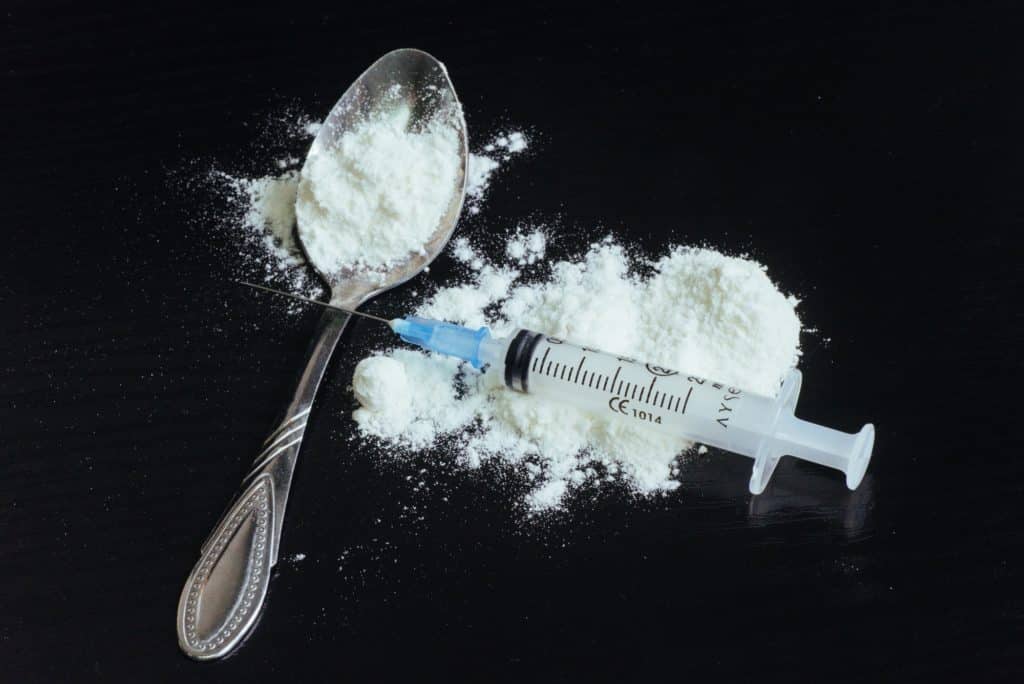 drug use, addiction and substance abuse concept - close up of spoon syringe with crack cocaine